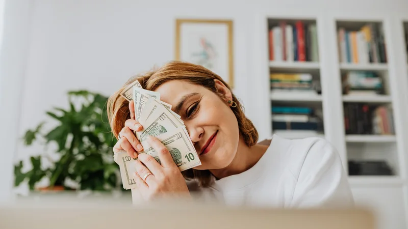 Woman with cash after receiving Credit Cube personal loan funds quickly